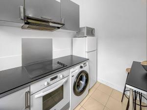 a kitchen with a washing machine and a refrigerator at Superbe appartement avec hauteur sous plafond à Poissy en plein centre Ville Ideal professionnels couples et famille in Poissy +8 photos