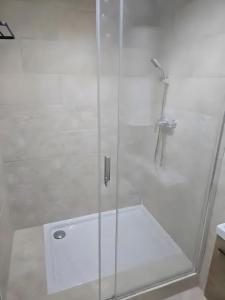 y baño con ducha blanca y puerta de cristal. en Canto Cigalo Duplex no 11, en Robion en Luberon