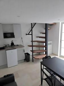 a kitchen with a table and a spiral staircase at Canto Cigalo Duplex no 11 in Robion en Luberon