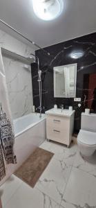 a bathroom with a sink and a tub and a toilet at AIRPORT/PARKING/VINIETA.MD in Chişinău +10 photos