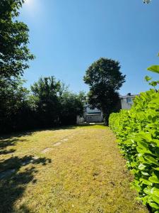 a grass field with trees and a house in the background at Apex Rooms Manchester in Manchester +11 photos