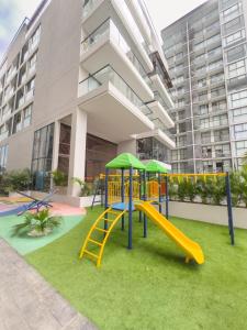 ein Spielplatz mit Rutsche vor einem Gebäude in der Unterkunft Nuevo apto familiar cerca al mar in Santa Marta