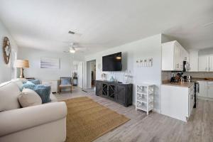 a living room with a couch and a kitchen at Cozy and charming getaway with deck, close to beach in Crystal Beach