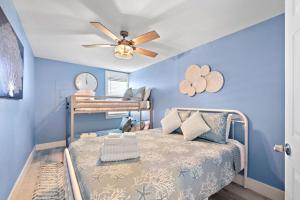 1 dormitorio azul con 1 cama y ventilador de techo en Cute beach house with large deck and fire pit, close to the beach, en Galveston 57 fotos más