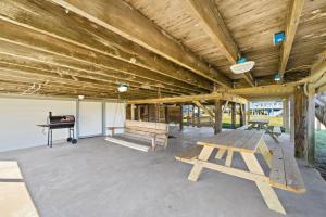 Una gran sala con una mesa de picnic y un piano. en Cute beach house with large deck and fire pit, close to the beach, en Galveston