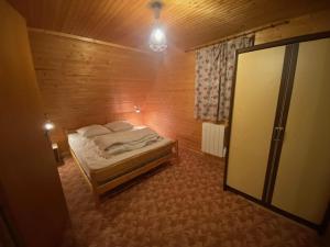 Un dormitorio con una cama en una habitación de madera. en Chalet des cimes étoilées, en Chastreix