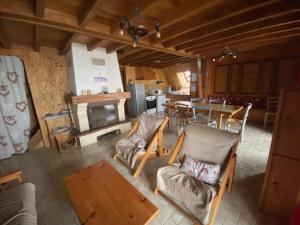 Una sala de estar con mesa y sillas y una cocina. en Chalet des cimes étoilées, en Chastreix