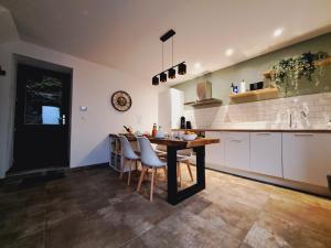 a kitchen with a table and chairs and a counter at Gîte Chez Nénene La Roche en Ardenne in La Roche-en-Ardenne