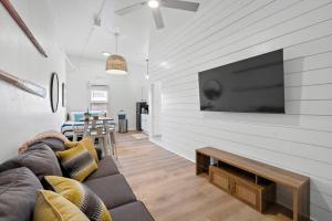 un soggiorno con divano e TV a schermo piatto di Modern Downtown Galveston Loft, Walk to The Strand a Galveston