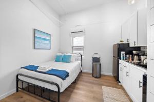 una piccola camera da letto con un letto e una cucina di Modern Downtown Galveston Loft, Walk to The Strand a Galveston
