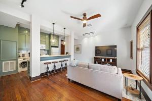 Historic loft in downtown Galveston close to everything في جالفيستون: غرفة معيشة مع أريكة ومطبخ