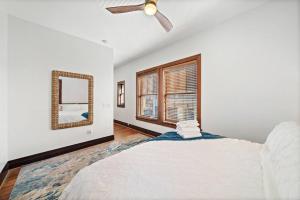Historic loft in downtown Galveston close to everything في جالفيستون: غرفة نوم بها سرير ومروحة سقف