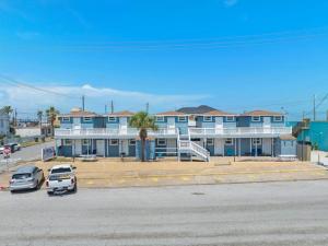 ガルベストンにあるCozy studio across the street from the seawall and close to Cruise Terminalの駐車場車の並ぶ青い建物 +26枚の写真