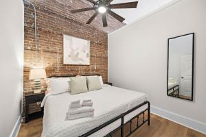 a bedroom with a large bed with a brick wall at Historic Downtown Galveston Flat With Game Room in Galveston
