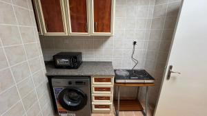 a kitchen with a washing machine and a stove at XD Hostel Apartments in Abu Dhabi