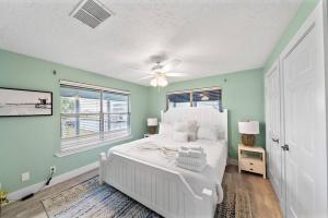 加尔维斯敦Waterfront canal with stunning pool and direct fishing access的卧室设有白色的床和绿色的墙壁 更多50张照片