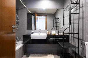 un bagno con un lavandino bianco e uno specchio di Parkside Serenity Stunning Open View 1 bedroom a Mushayrib Altre 2 foto