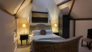 a bedroom with a bed and two tables and two lamps at The Fat Fox in Pyrton