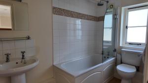 Un baño con bañera, inodoro y lavabo. en The Fat Fox, en Pyrton