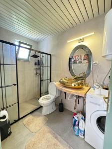 ein Badezimmer mit Toilette, Waschbecken und Spiegel in der Unterkunft Luxury villa in mountain in Geyikbayırı
