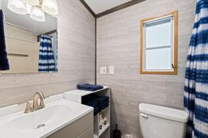 a bathroom with a sink and a toilet and a mirror at Tucked Away - Magical Location on the River, Hiking, and Rafting in Dillsboro +14 photos