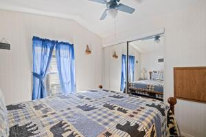 a bedroom with a bed with blue curtains and a mirror at Tucked Away - Magical Location on the River, Hiking, and Rafting in Dillsboro