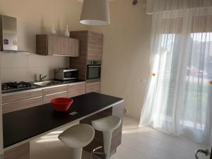 a kitchen with a counter and two stools at Calipso in Abano Terme