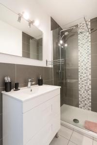 a white bathroom with a sink and a shower at Appartement confortable avec balcon - Proche Gare Riquier SNCF in Nice