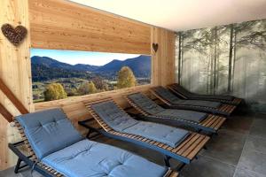 a room with three chairs and a window with mountains at House Martina in Limana