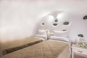 Un dormitorio con dos camas en una habitación blanca. en Excelent Villa Santorini, en Vlychada