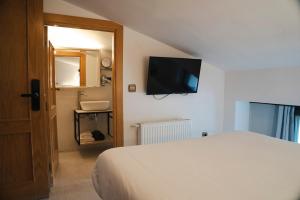 a bedroom with a bed and a television on the wall at El Ciervo in Villaciervos +31 photos