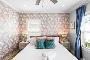 a bedroom with a bed and two windows at Family Friendly 3-Bedroom Coastal Escape in Galveston