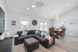 ein Wohnzimmer mit Couch und ein Esszimmer in der Unterkunft Beach bungalow with large, wrap-around deck, close to beach in Galveston