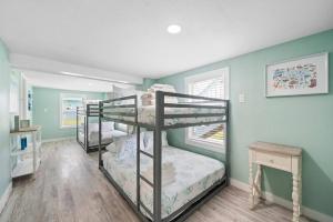 3 Etagenbetten in einem Zimmer mit blauen Wänden in der Unterkunft Beach bungalow with large, wrap-around deck, close to beach in Galveston + 57 Fotos