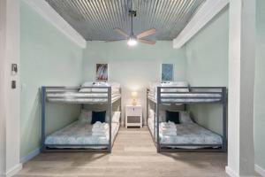 a room with three bunk beds and a ceiling at Waterfront beach house with the ultimate game room and two docks in Oyster Creek