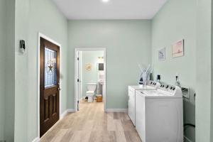 a bathroom with a sink and a washer and dryer at Waterfront beach house with the ultimate game room and two docks in Oyster Creek +46 photos