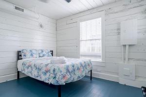 une chambre blanche avec un lit et une fenêtre dans l'établissement Historic charmer close to all the beach and strand, à Galveston