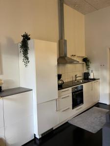 a kitchen with a white refrigerator and a sink at Gården in Sønder Felding