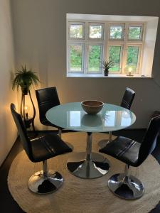ein Esszimmer mit einem Glastisch und Stühlen in der Unterkunft Gården in Sønder Felding + 2 Fotos