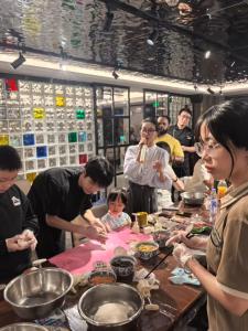 een groep mensen die rond een tafel staan om voedsel te bereiden bij Nostalgia S Hotel Beijing Guomao CBD in Beijing