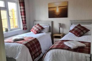 une chambre avec deux lits et un tableau au mur dans l'établissement 2 Bed Cabin - Sleeps 4 - Pets - 5 min to Beach, à Bridlington