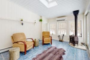 un soggiorno con due sedie e un camino di Juniper Grove a Ogunquit