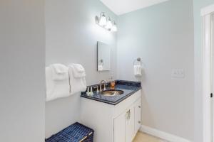 un bagno bianco con lavandino e specchio di Juniper Grove a Ogunquit