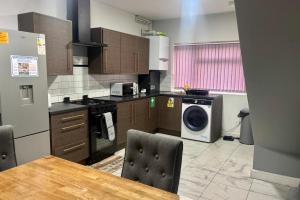 a kitchen with a table and a washing machine at 2 Bed House-Sleeps 4-Free Parking in Dudley