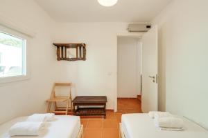 a room with two beds and a chair and a window at NEW! Quinta de Zanão House in Palmela