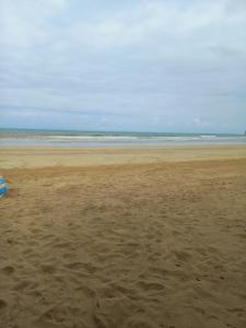 een zandstrand met de oceaan op de achtergrond bij kitinet IMMANU'EL Moreré-Ba in Cayru