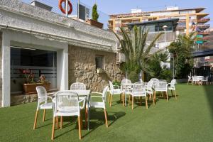a row of white chairs and tables on a lawn at Sercotel Maya Alicante in Alicante