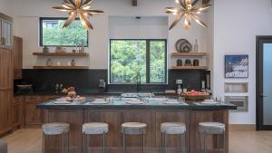 a kitchen with a large island with bar stools at Aria Ridge in Steamboat Springs +26 photos