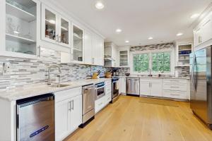 a kitchen with white cabinets and stainless steel appliances at Trent Jones Cottage at Point O' Woods in Benton Harbor