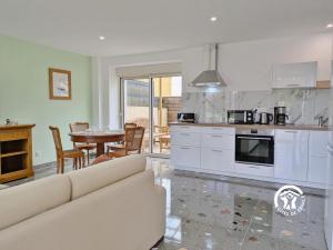 a kitchen and dining room with a couch and a table at La Maison du Bourg, 4 personnes in Louverné